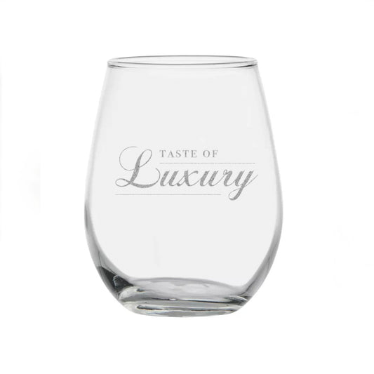 A stemless wineglass that says “Taste of Luxury” in gold lettering. “Luxury” is written in script.