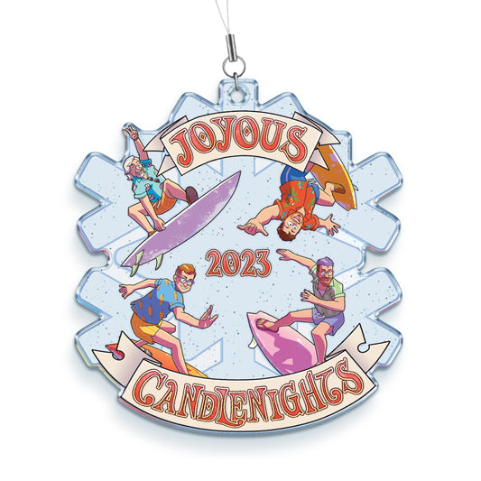 A transparent acrylic ornament in the shape of a snowflake. There is an illustration of the four McElroys surfing in colorful Hawiian shirts and shorts. There’s a banner at the top that says, “Joyous,” and at the bottom that says, “Candlenights.” In the center it says, “2023”.