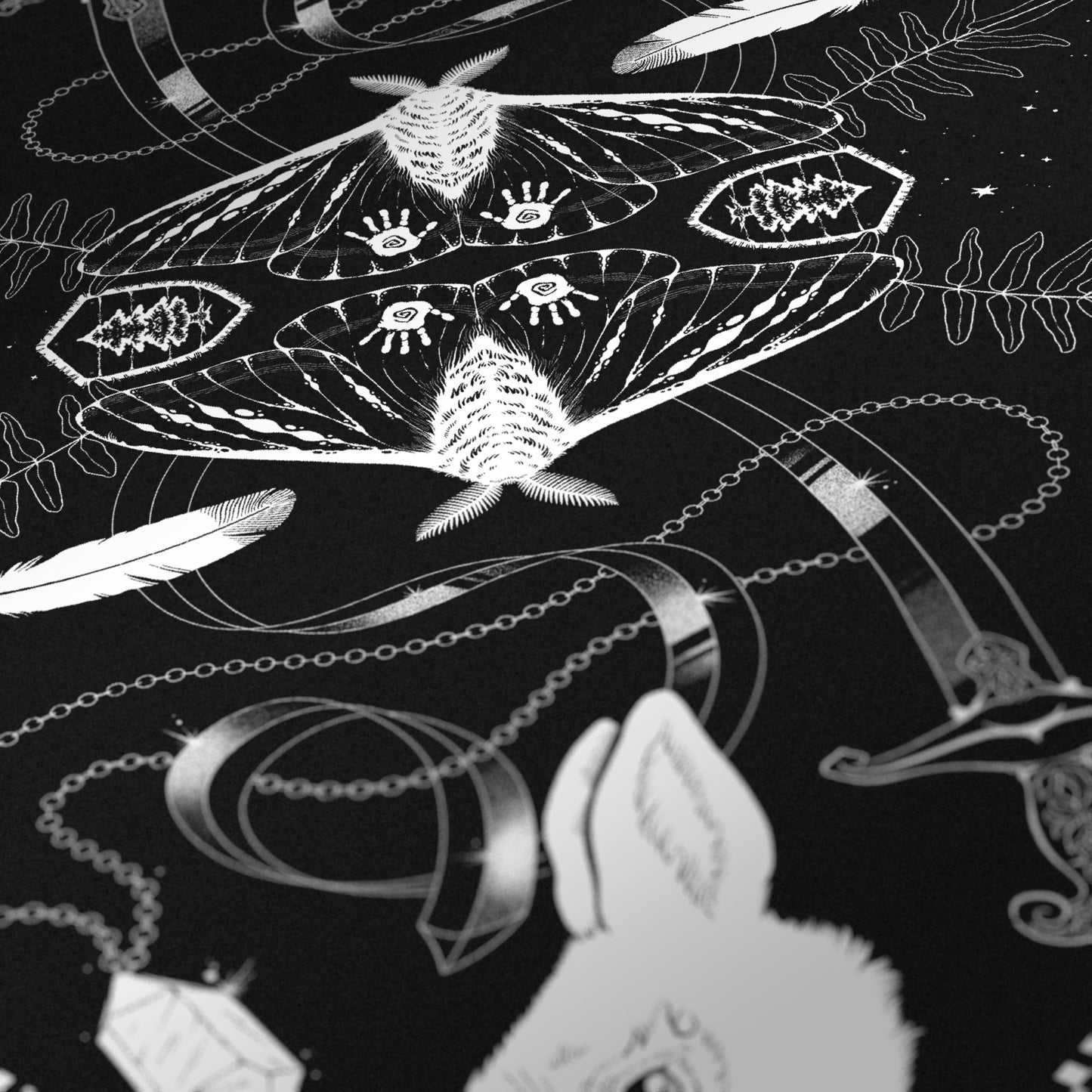 A black bandana with white illustrations inside a checkerboard border. From the center outward, there are illustrations that are mirrored on the other side: a moth with its wings spread, a Parks Ranger emblem, a fern, a bendy sword, a feather, a crystal on a chain, a goat’s head, a skull, a rabbit’s head, a house lit by a full moon, and a bigfoot walking across the border