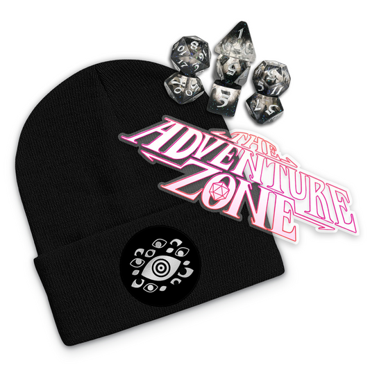 Black beanie with black woven patch on cuff and silver embroidered eye design on the patch. Set of acrylic dice with glitter and black faded gradient. Clear die cut sticker that says, "The Adventure Zone" in white with pink outlines.