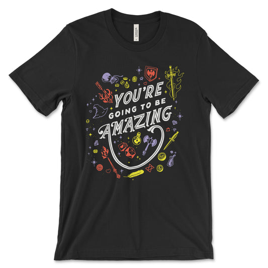 A mockup of a black shirt featuring a design of D&D themed accessories scattered around the phrase "You're going to be amazing" The Accessories include dice, swords, shields, coins, axes, potions, gems and symbols and are illustrated in red, orange and purple.