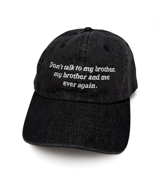 A black baseball cap with white embroidered text on the front. The text says, “Don’t talk to my brother, my brother and me ever again.”