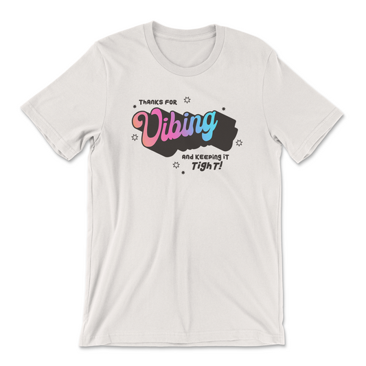 A white crew neck t-shirt with the text 'Thanks for Vibing and keeping it tight!" in a groovy brown font with Vibing a gradient of pink to blue.