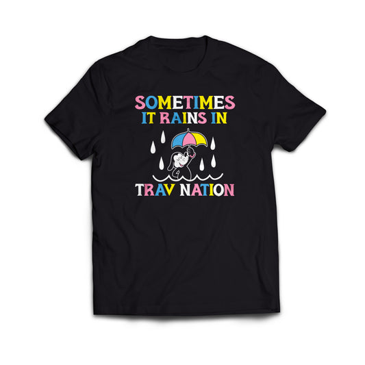 A black tee shirt with a cartoon dog holding an umbrella with white raindrops in the center. In colorful text above and below it says, “Sometimes it rains in Trav Nation.”