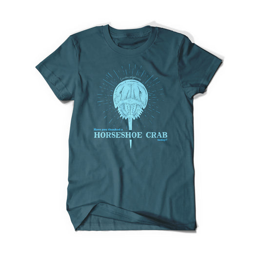 A blue-green shirt with an illustration of a light blue horseshoe crab on it. Below the illustration it says, "Have you thanks a horseshoe crab today?" in shades of blue. 