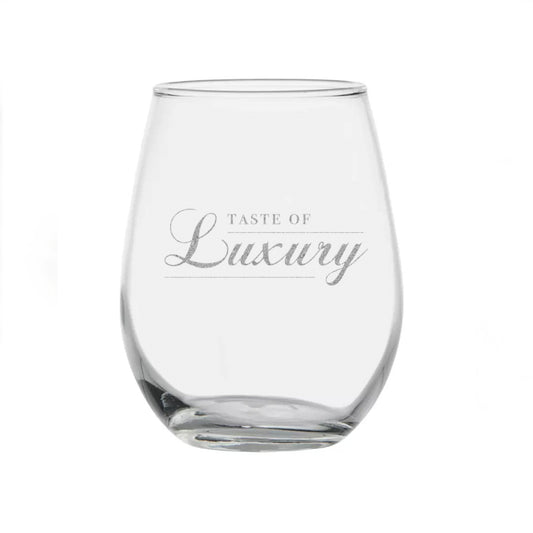 A stemless wineglass that says “Taste of Luxury” in gold lettering. “Luxury” is written in script. 