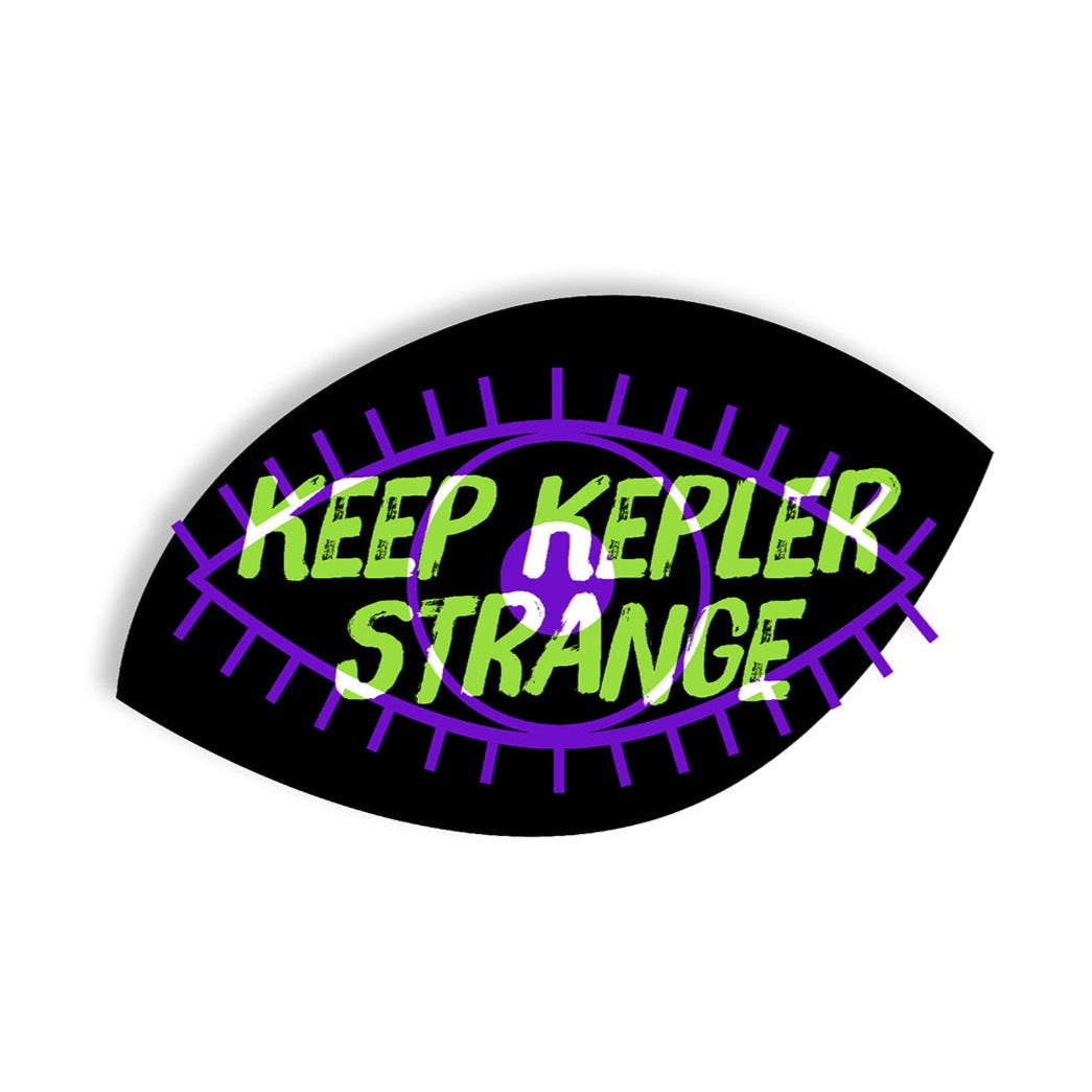 A black eye-shaped sticker. There is a purple line drawing of an eye in the center of the sticker. Over that is says, "Keep Kepler Strange" in lime green and white.