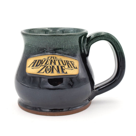 A green and dark brown stoneware mug with a The Adventure Zone logo in cream on the front. 
