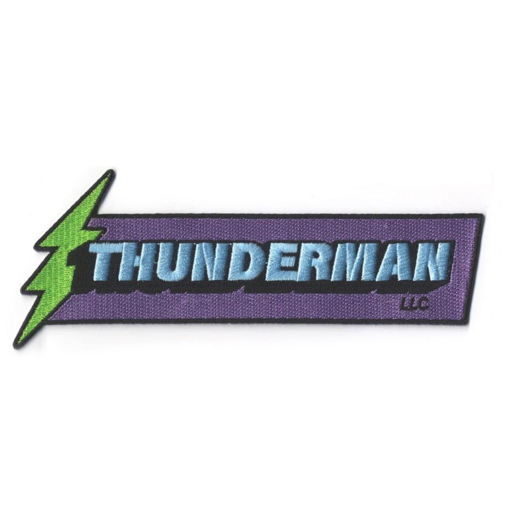 A rectangular purple patch with a lime green thunderbolt on the left side. In the center it says “Thunderman” in bright blue block letters with a black drop shadow. Below the drop shadow is an “LLC” mark.
