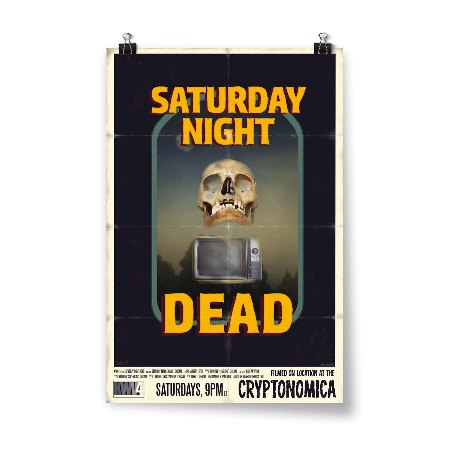 Image of a retro poster. In the center is a skull hovering over an old-fashioned TV. The backgound is a hazy forest scene. It's surrounded by a thin light blue border with a thick black border around that. Above it are the words "Saturday night" and below is the word "dead" in yellow with a maroon drop shadow. At the bottom of the poster it says "Saturdays, 9PM ET" and "Filmed on location at the Cryptonomica".