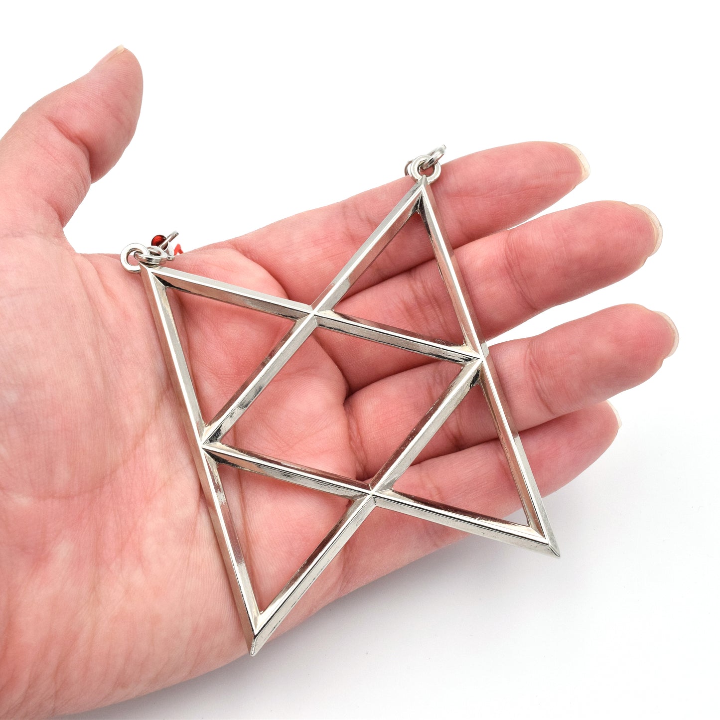 A silver metal ornament is the shape of the BoB symbol. The hanger is a red thread that strings across the top two points.